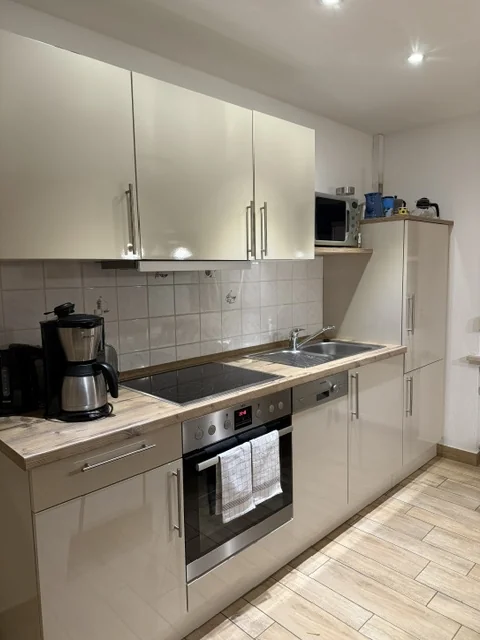 Küchenzeile mit Backofen, Kochfeld, Spüle und Kaffeemaschine