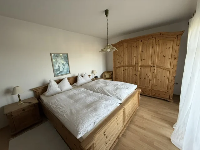 Schlafzimmer 1 mit Doppelbett und Holzschrank