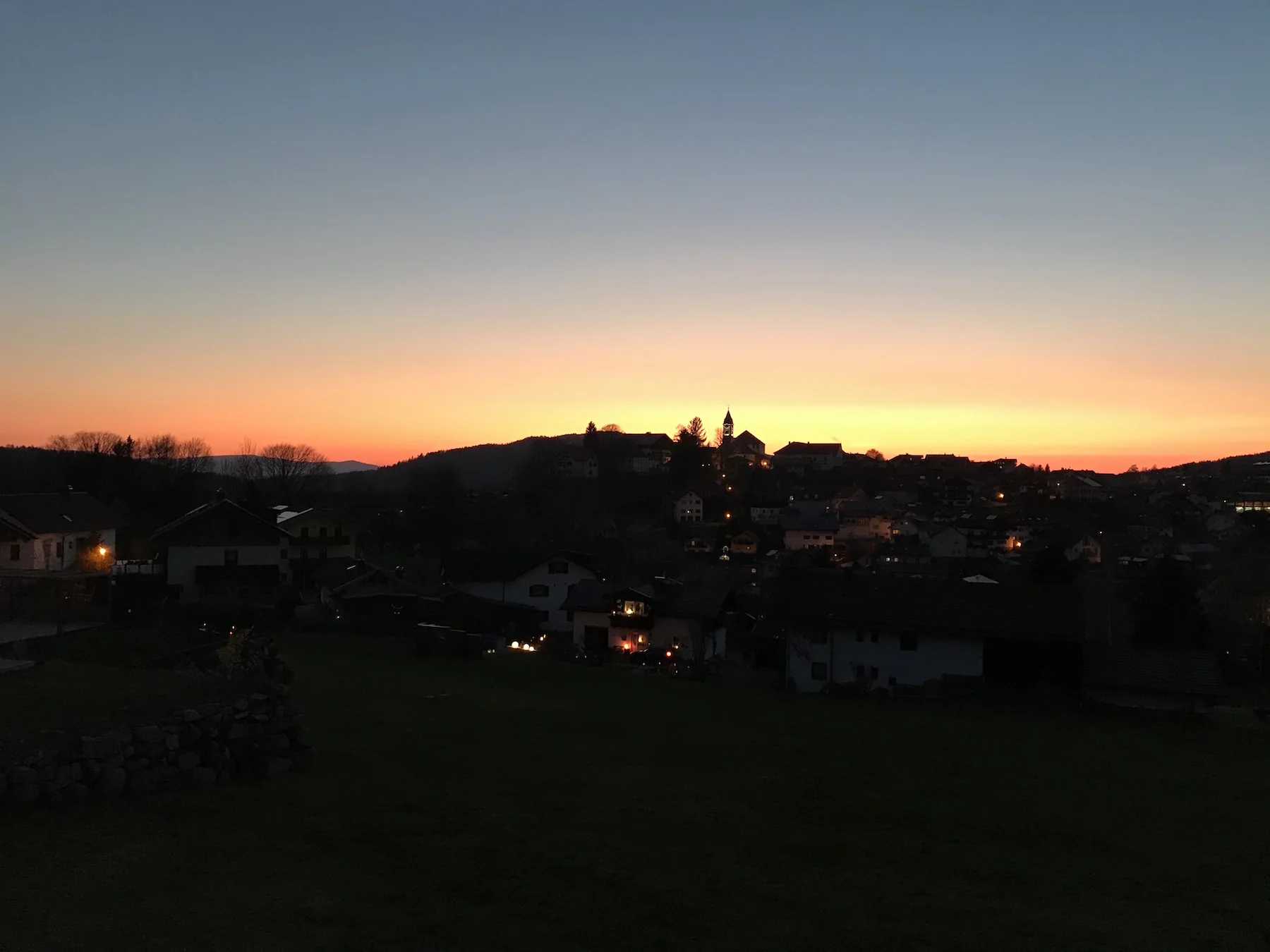 Abendstimmung über Bodenmais mit orangefarbenem Horizont und beleuchteten Häusern